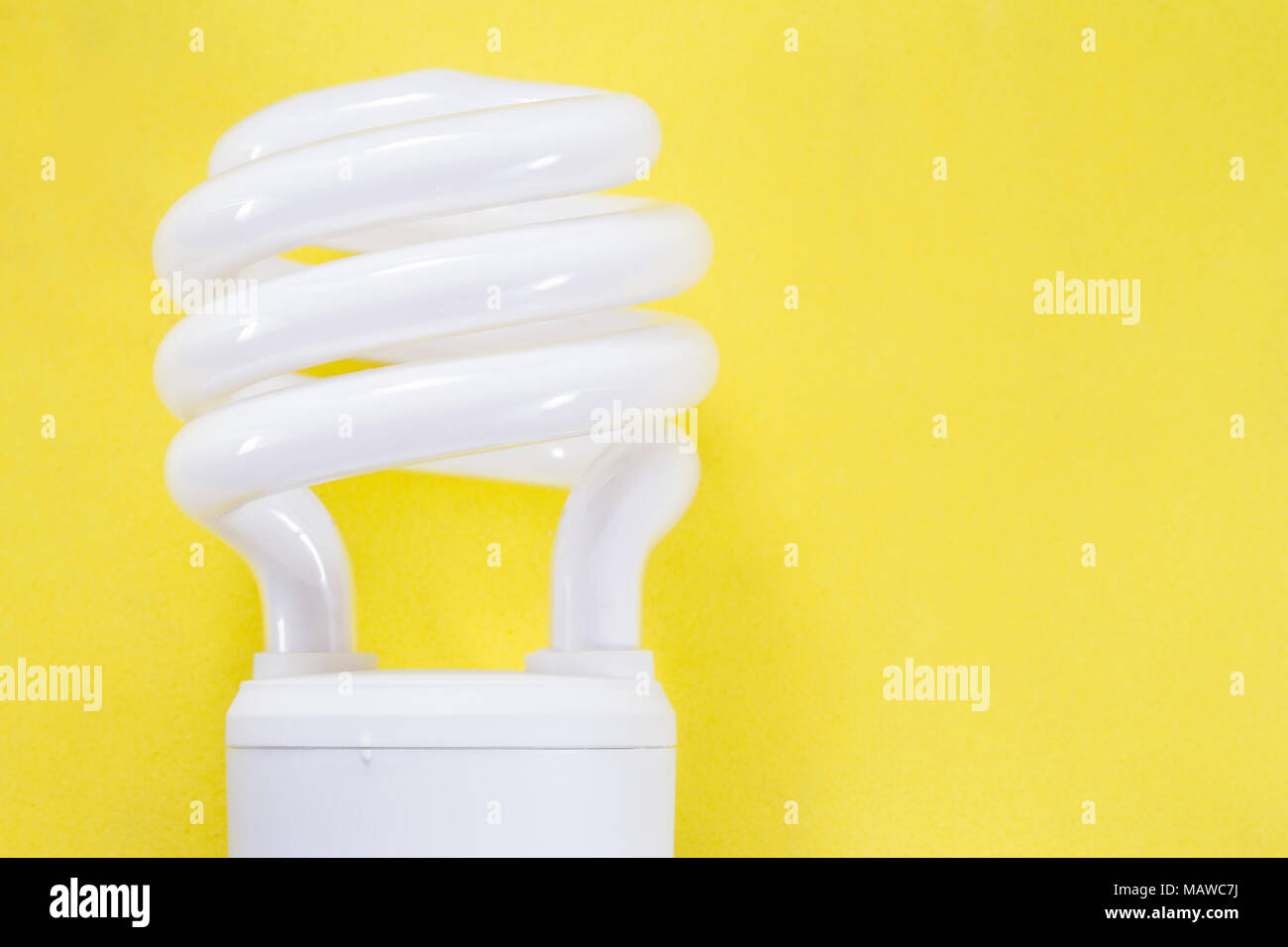 Fluorescent light bulb on yellow background, technology that contains