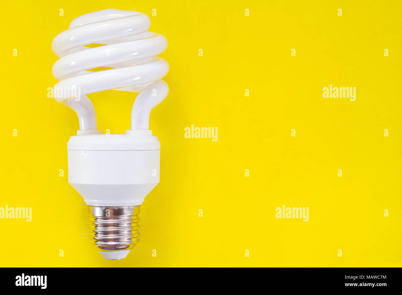 Fluorescent light bulb on yellow background, technology that contains