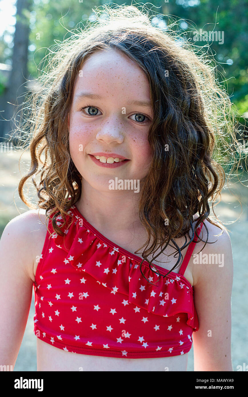 A Girl With Curls Backlit Looking At The Camera 7 9 Years Old Stock 