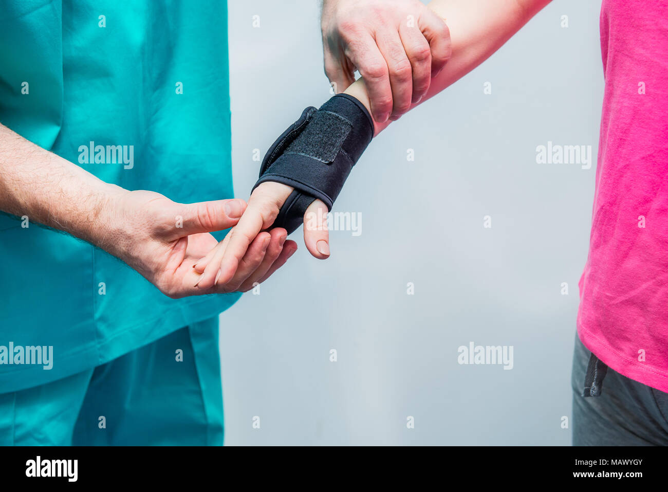 Close up Neurologist doctor, therapist puts on wrist retainer on young female patient's hand. Pain treatment. Neurology, Osteopathy, chiropractic. Sel Stock Photo