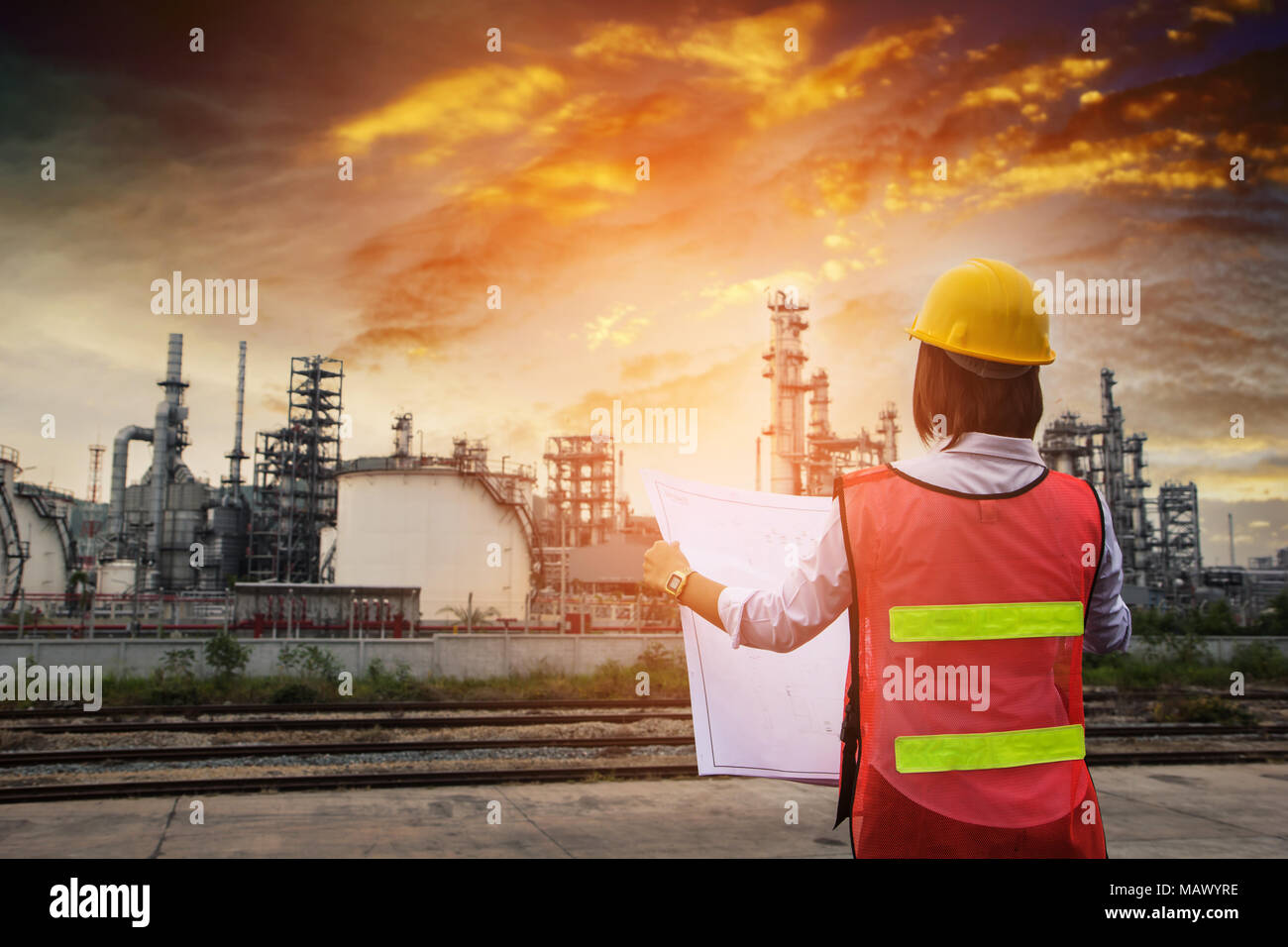 The people worker women engineer work control at power plant energy industry manufacturing oil refinery. Engineering check plant with blue print at su Stock Photo
