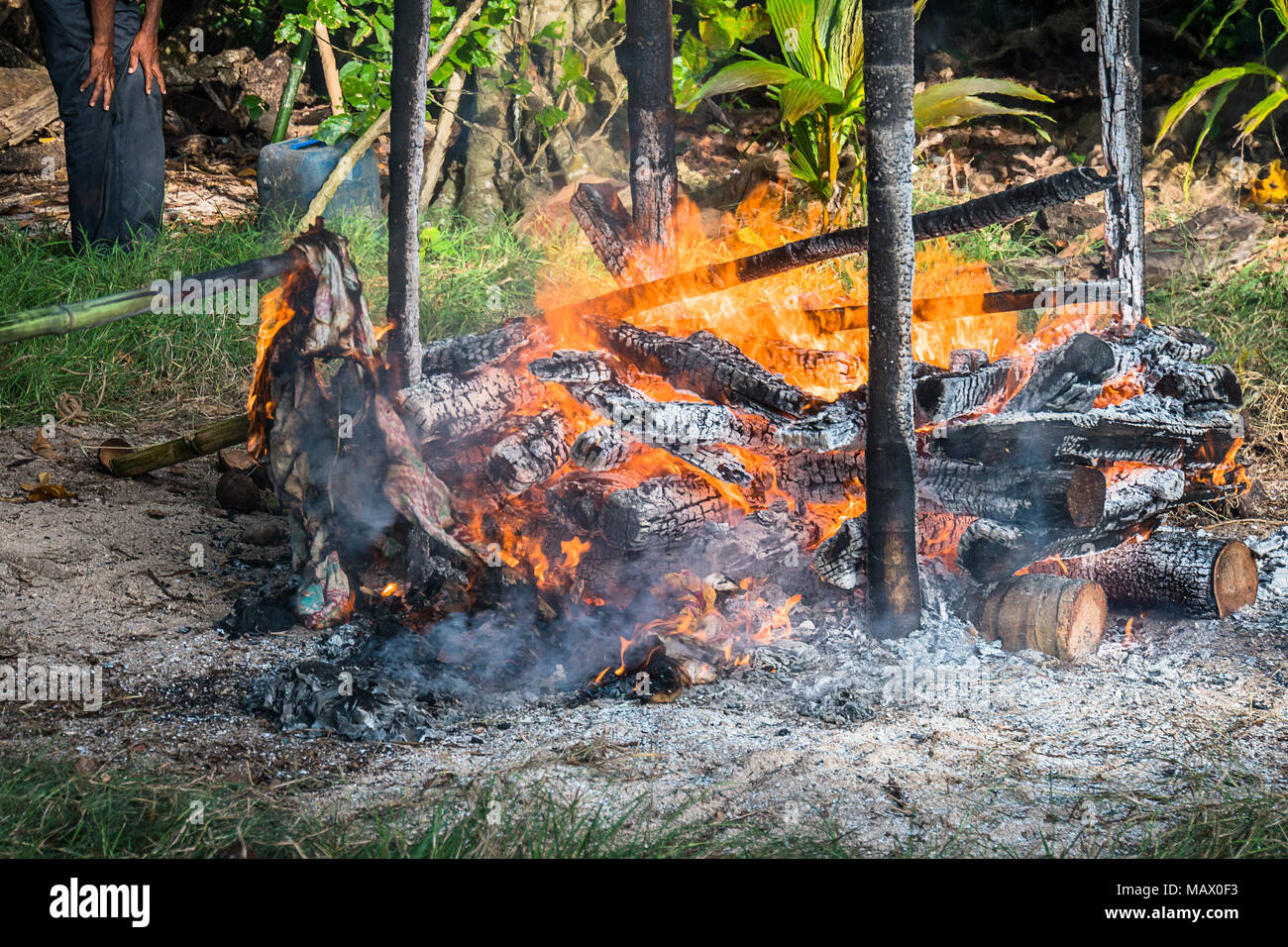 The process of cremation in the Andaman and Nicobar Islands. Hindu traditions. The islanders of the deceased are cremated on the bonfire on the shore  Stock Photo