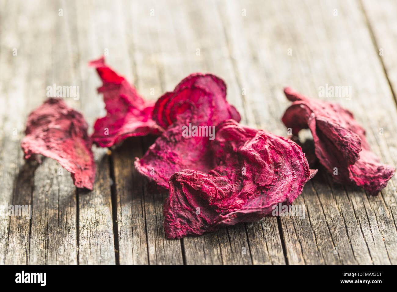 Dried beetroot chips on old wooden table. Stock Photo