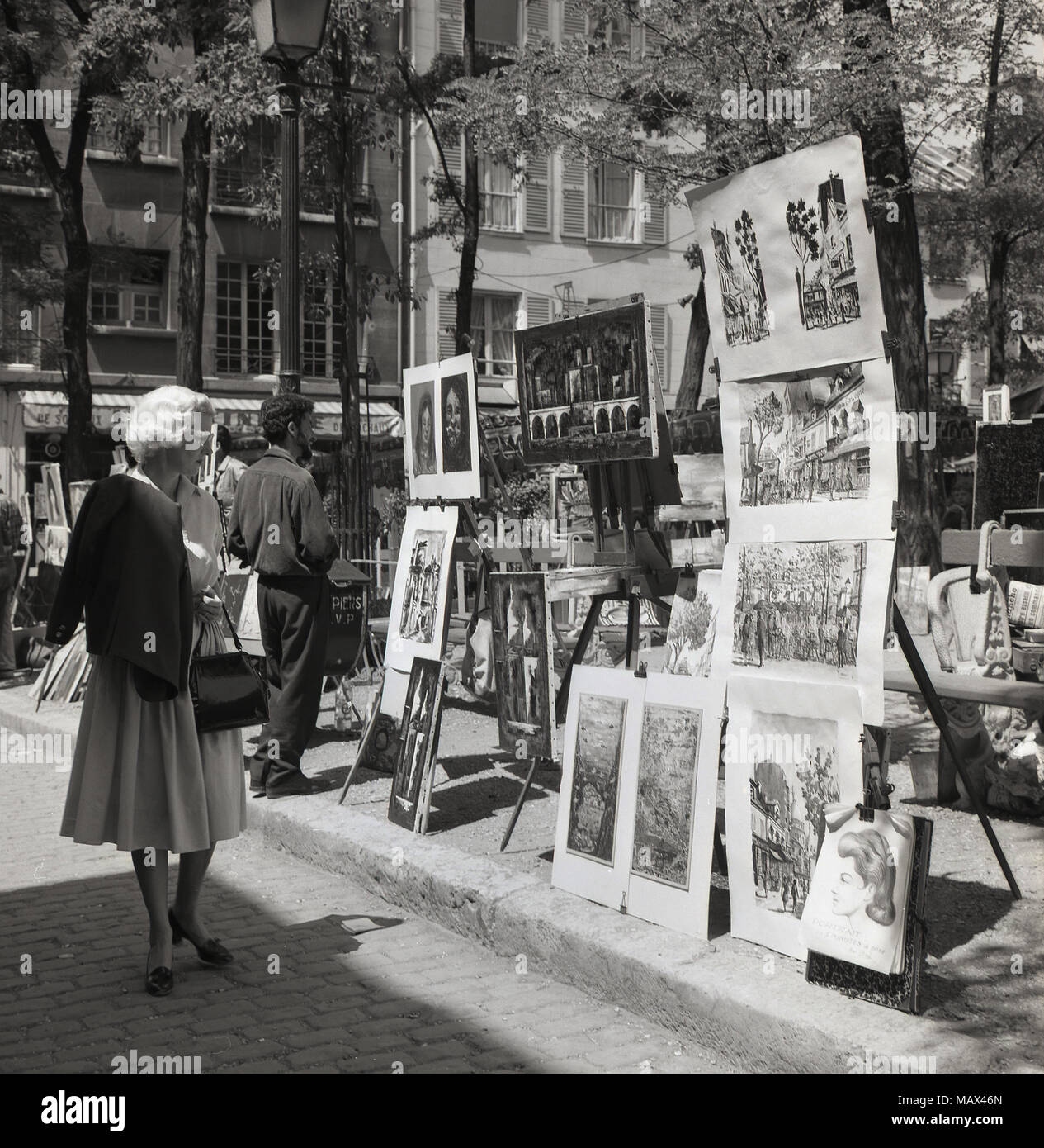 1950s, historical picture showing paintings and artwork on sale on the 'Place du Tertre', a famous square at Montmartre, Paris, France. The area is well-known for its street artists and there have many notable ones who have lived and worked there in the past, including Renoir and Picasso, Stock Photo