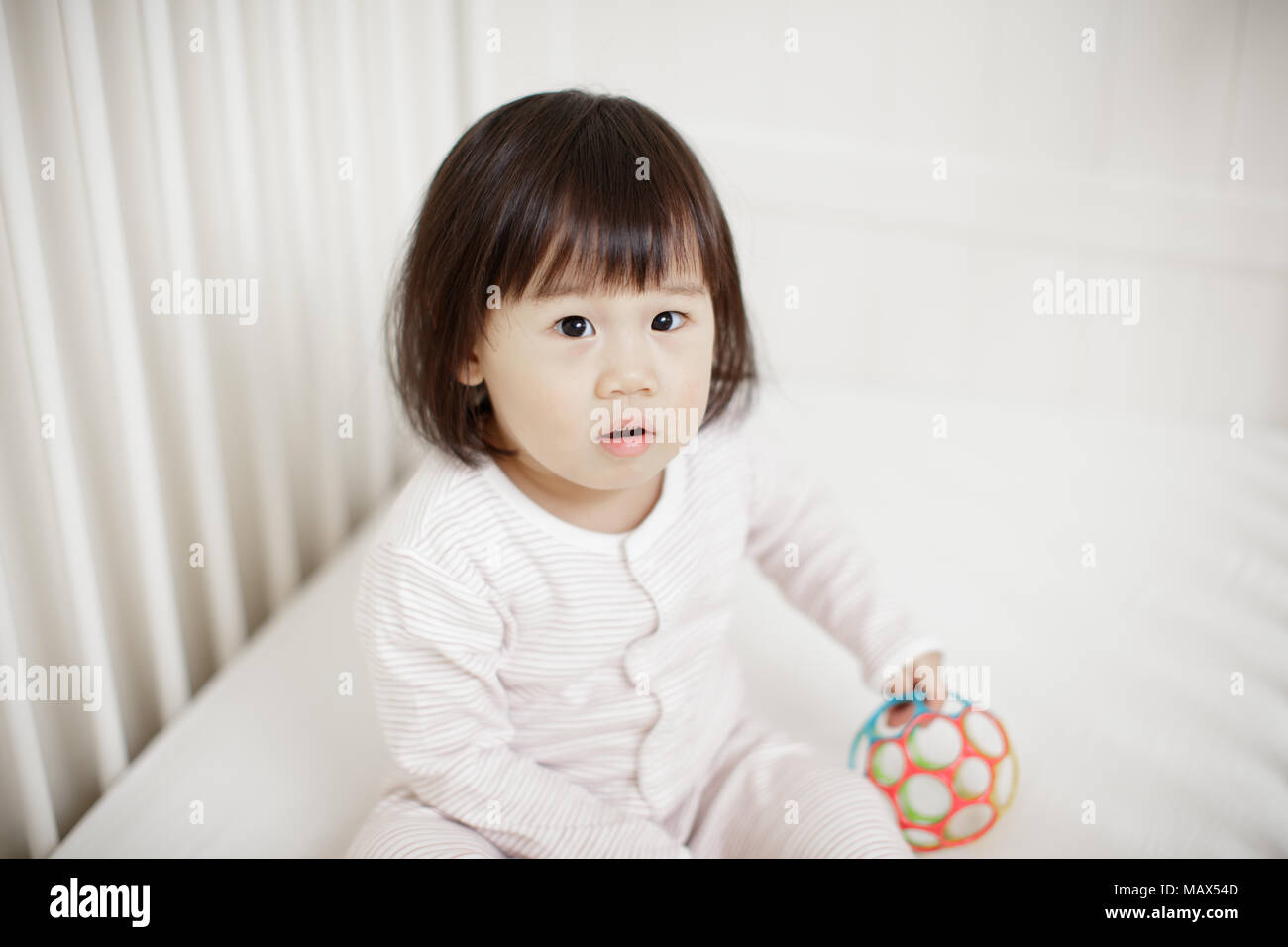 Baby girl in cot bed Stock Photo Alamy