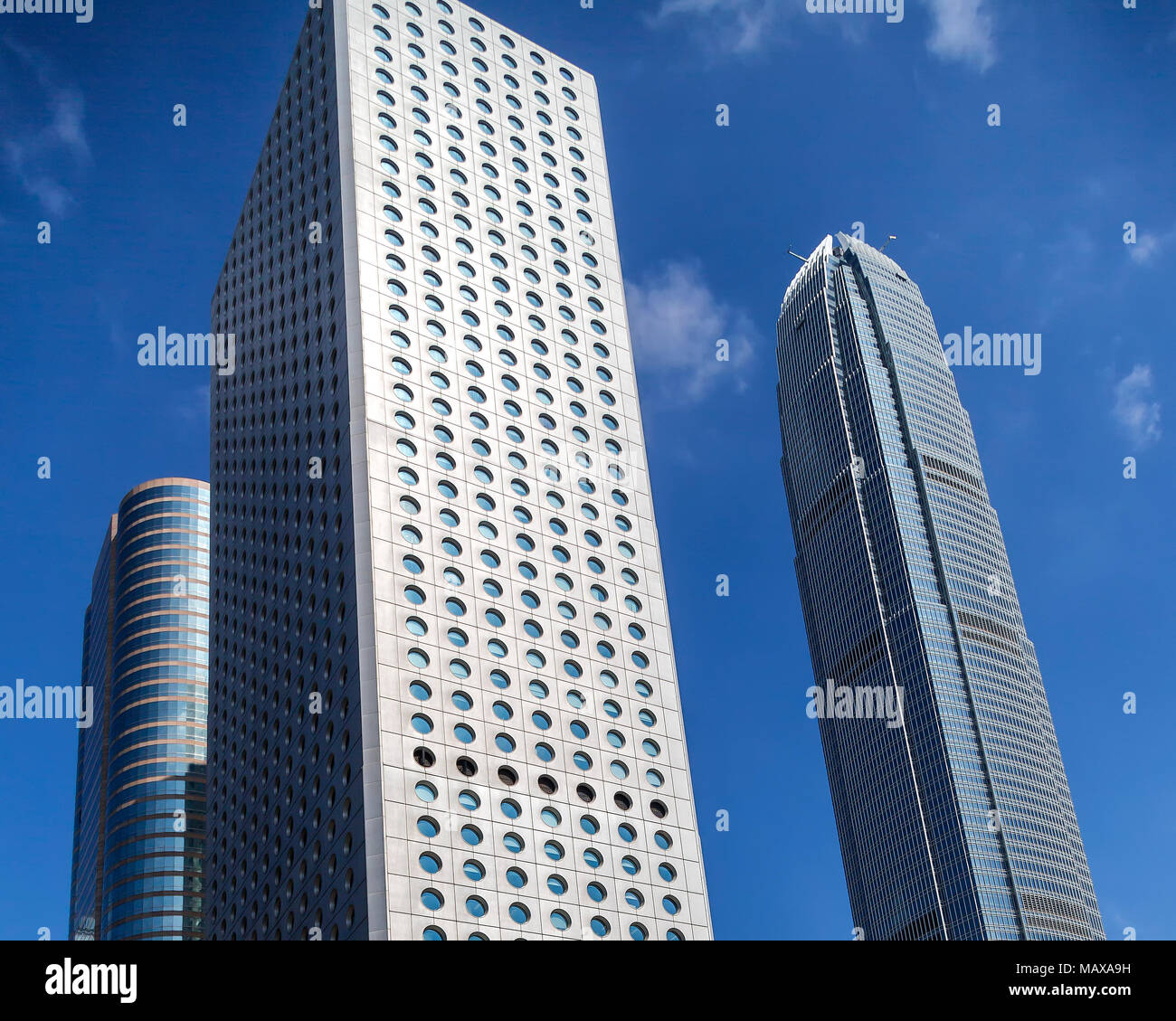 Jardine House with its round windows stands next to Two International Finance Centre in the Central district of Hong Kong. Stock Photo
