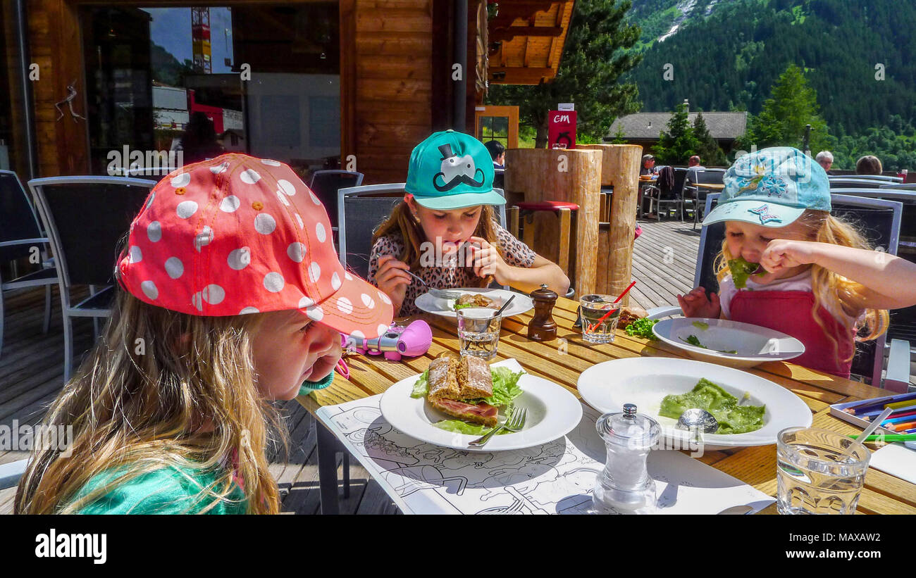 Children, kid eating lunch, al fresco, on a bright sunny day,  Seiss Alps, Switzerland Stock Photo