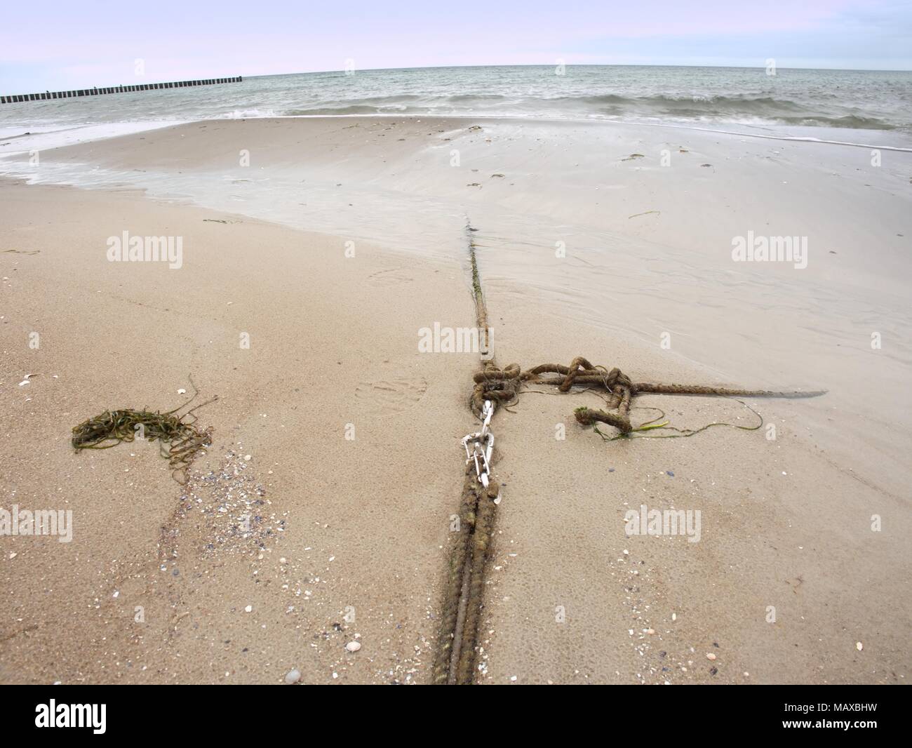 Ship old anchor rope with snap hook and line under sea. Steel shackle