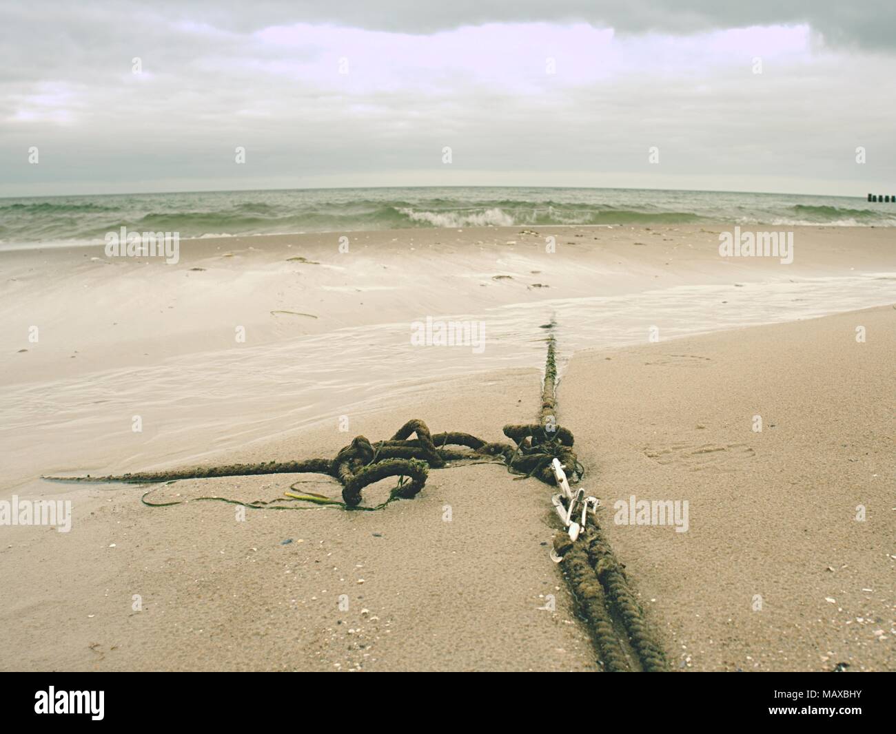 Ship old anchor rope with snap hook and line under sea. Steel shackle