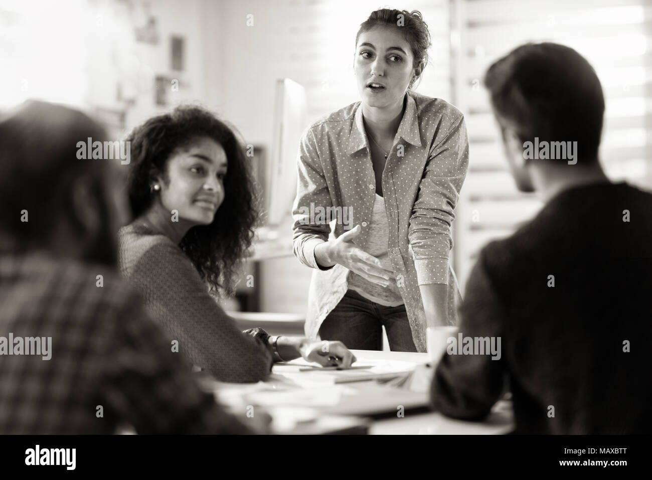 meeting at the company. A young woman leads a multi-ethnic worki Stock ...