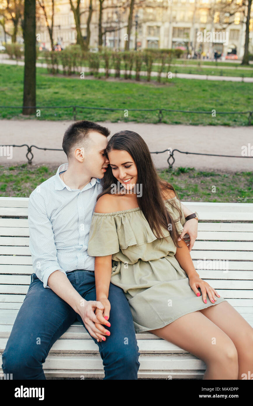 Happy young couple in love sitting on a park bench Stock Photo - Alamy