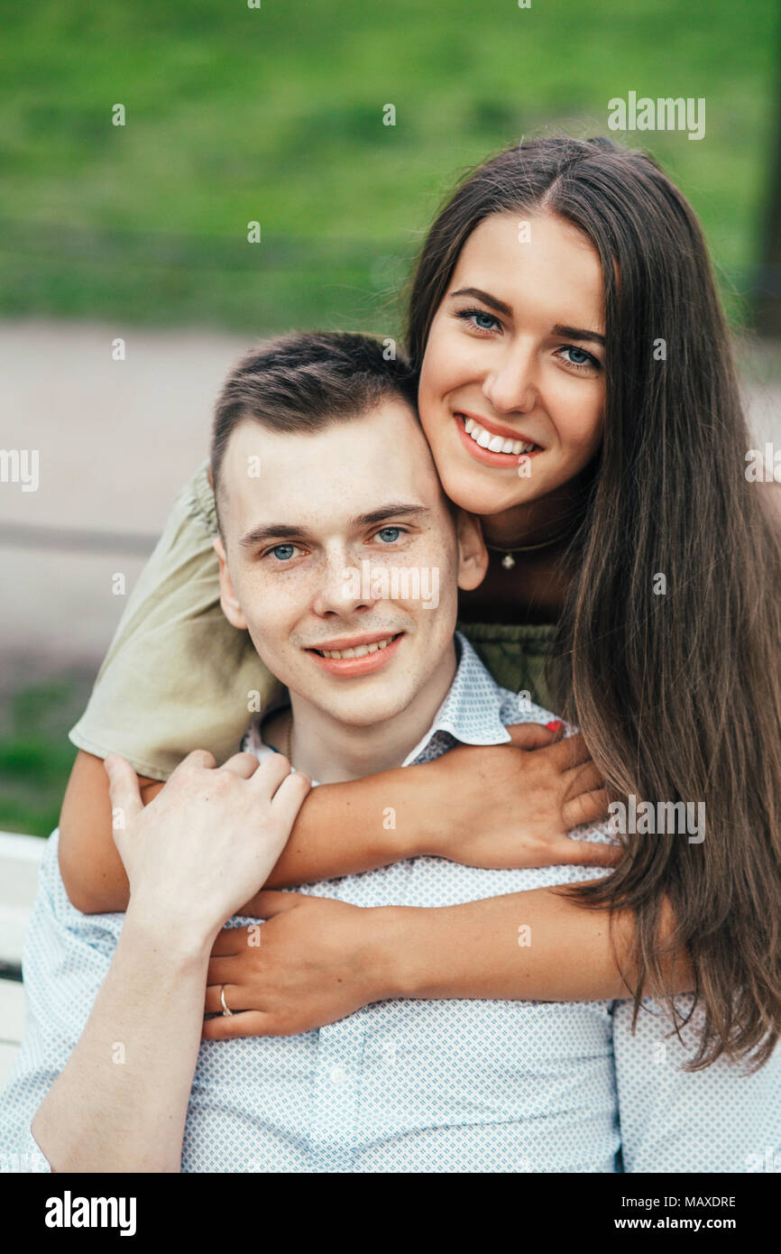 Happy young couple in love sitting on a park bench Stock Photo - Alamy