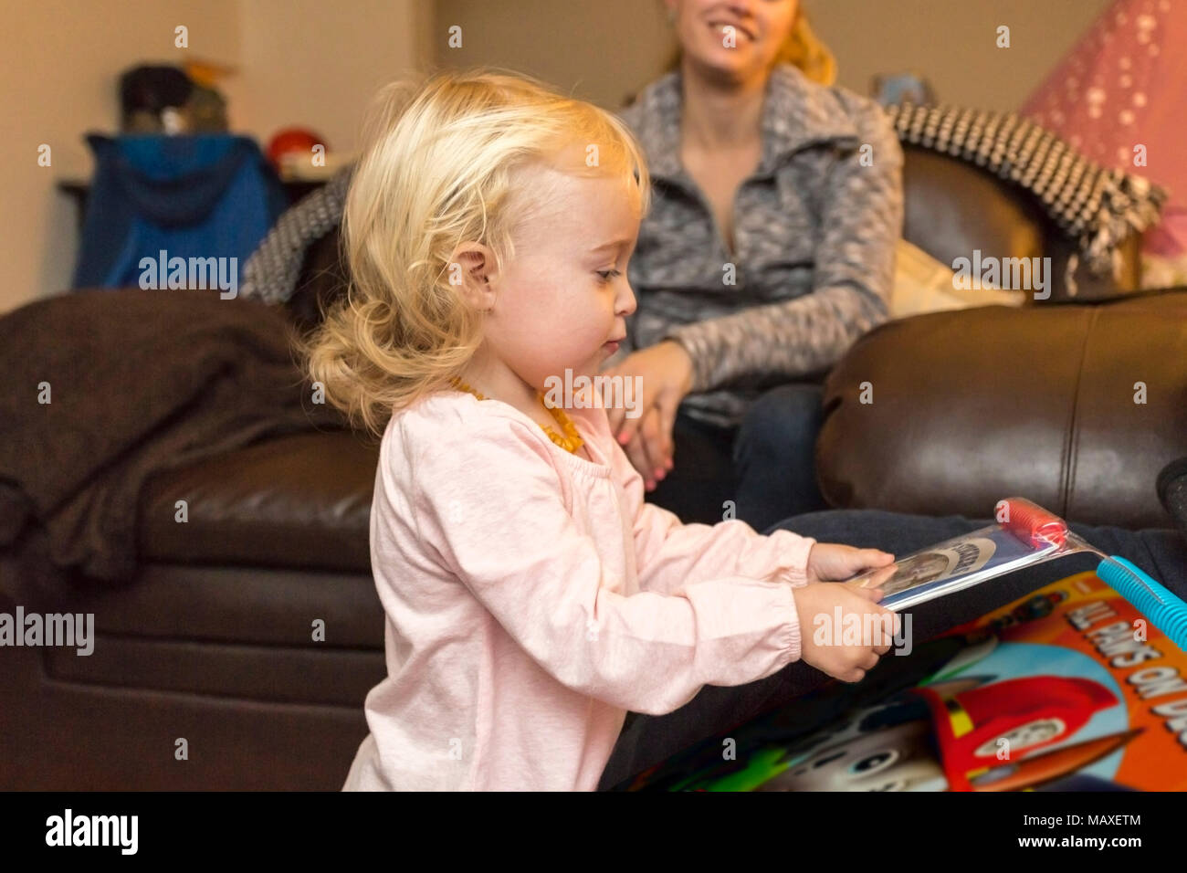 mother watching child playing with books on her birthday, Canada, Ontario Stock Photo