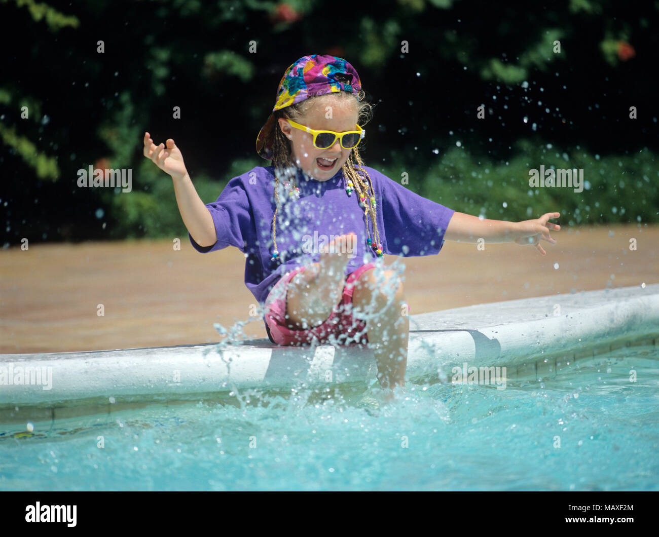 child splashing in pool Stock Photo