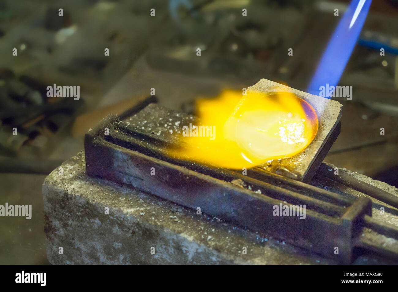 Jeweler putting melting silver on wire ingot mold using a gas oxygen torch Stock Photo Alamy