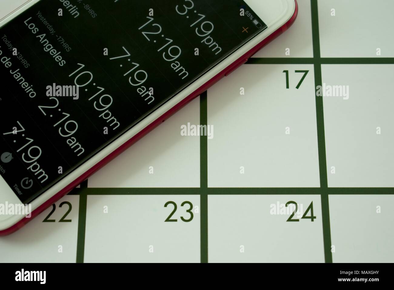 A calendar and world clock on mobile phone are used to travel to different time zones Stock Photo