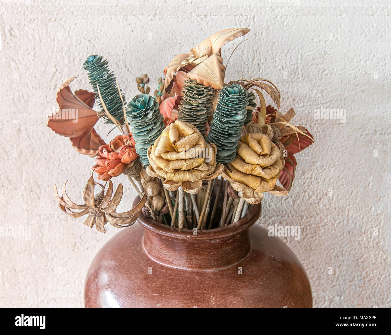 Decorative arrangement of flowers that aren't real put in a big vase on