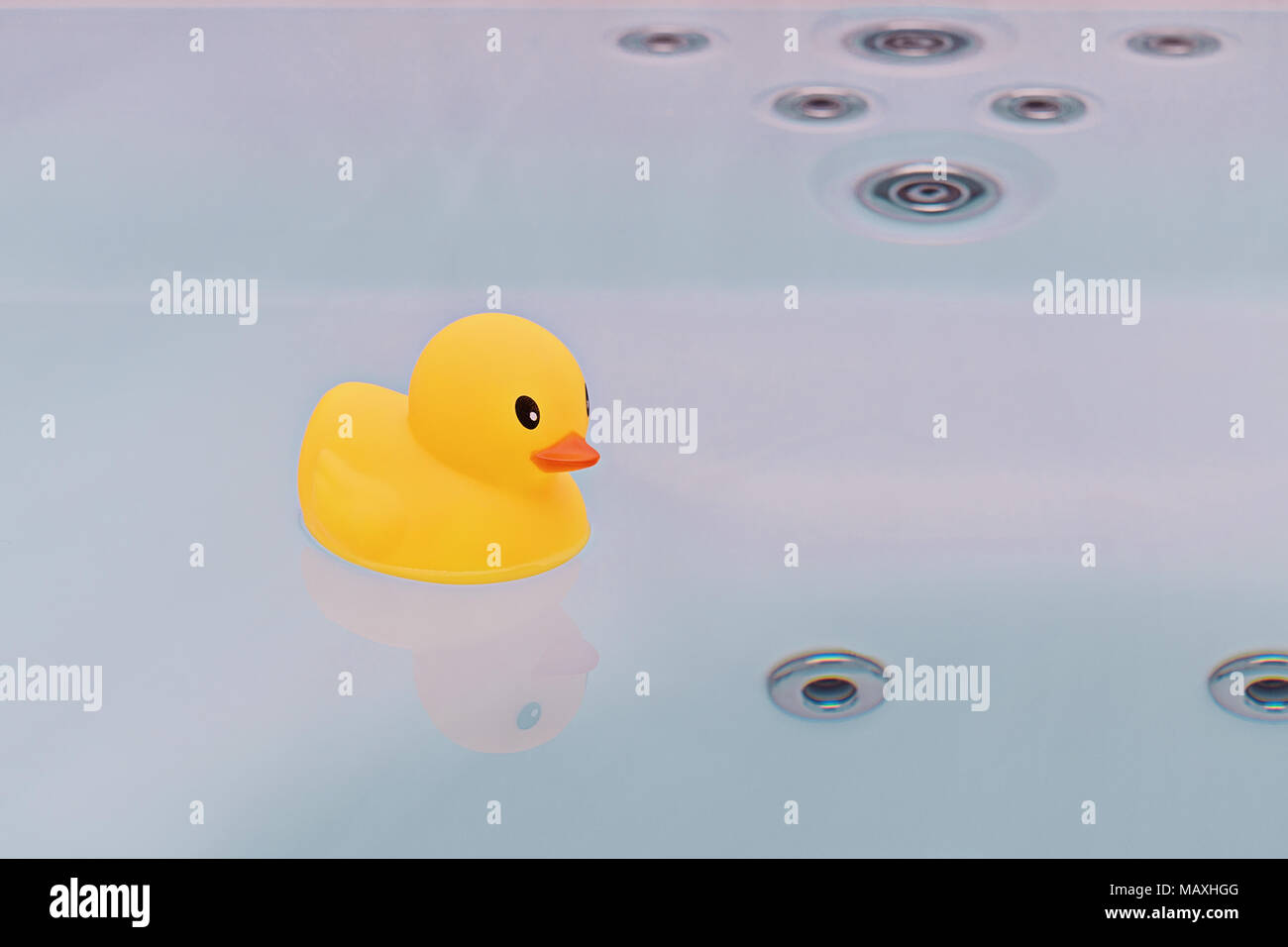 Large yellow rubber duck floating in bathtub jacuzzi. Bath time concept