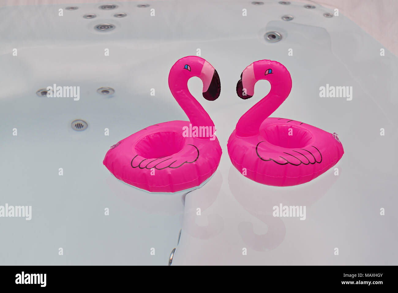 Couple of floating pink flamingo in bathtub, jacuzzi and party summer time concept Stock Photo