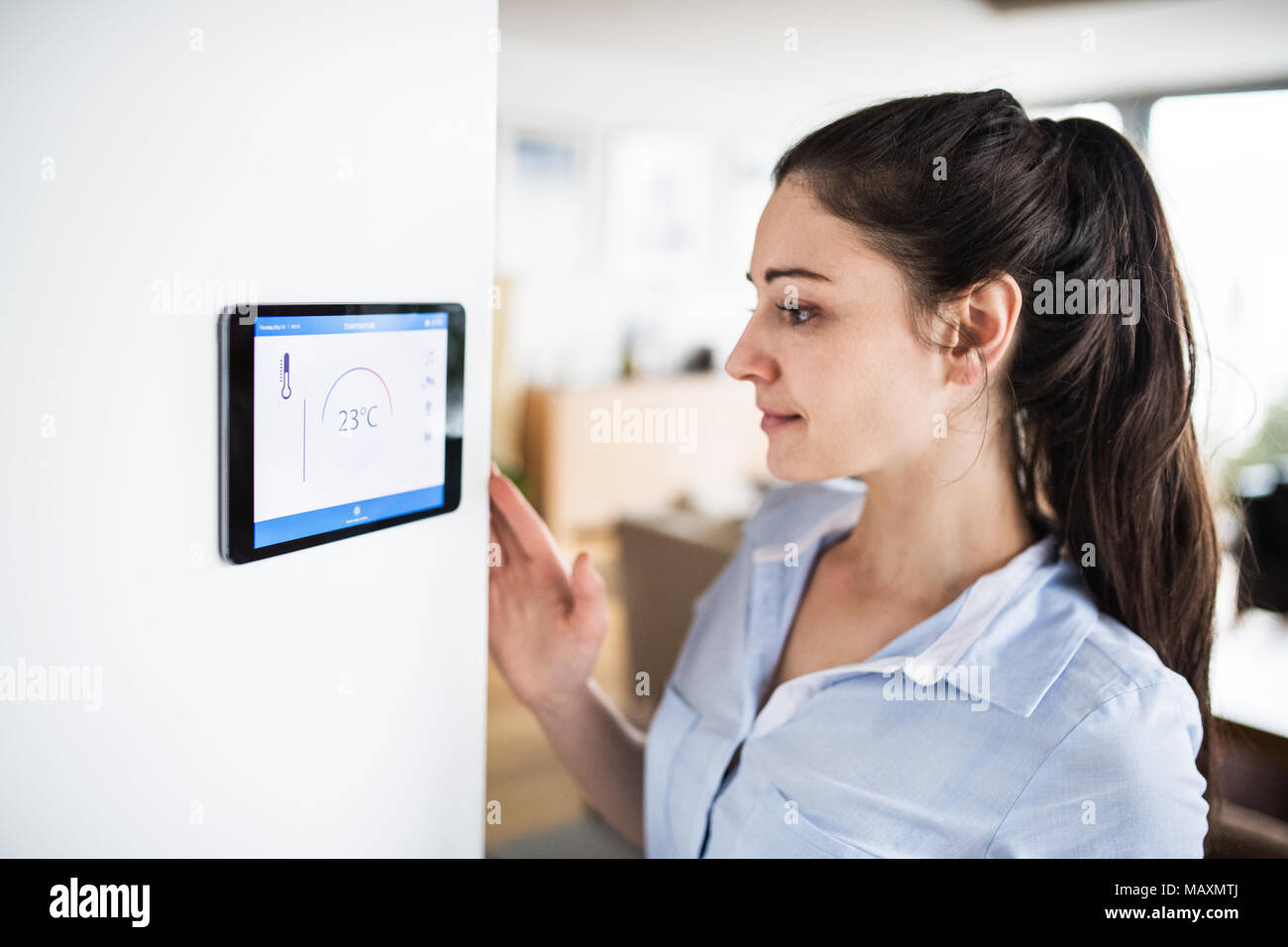 A woman looking at tablet with smart home screen Stock Photo - Alamy