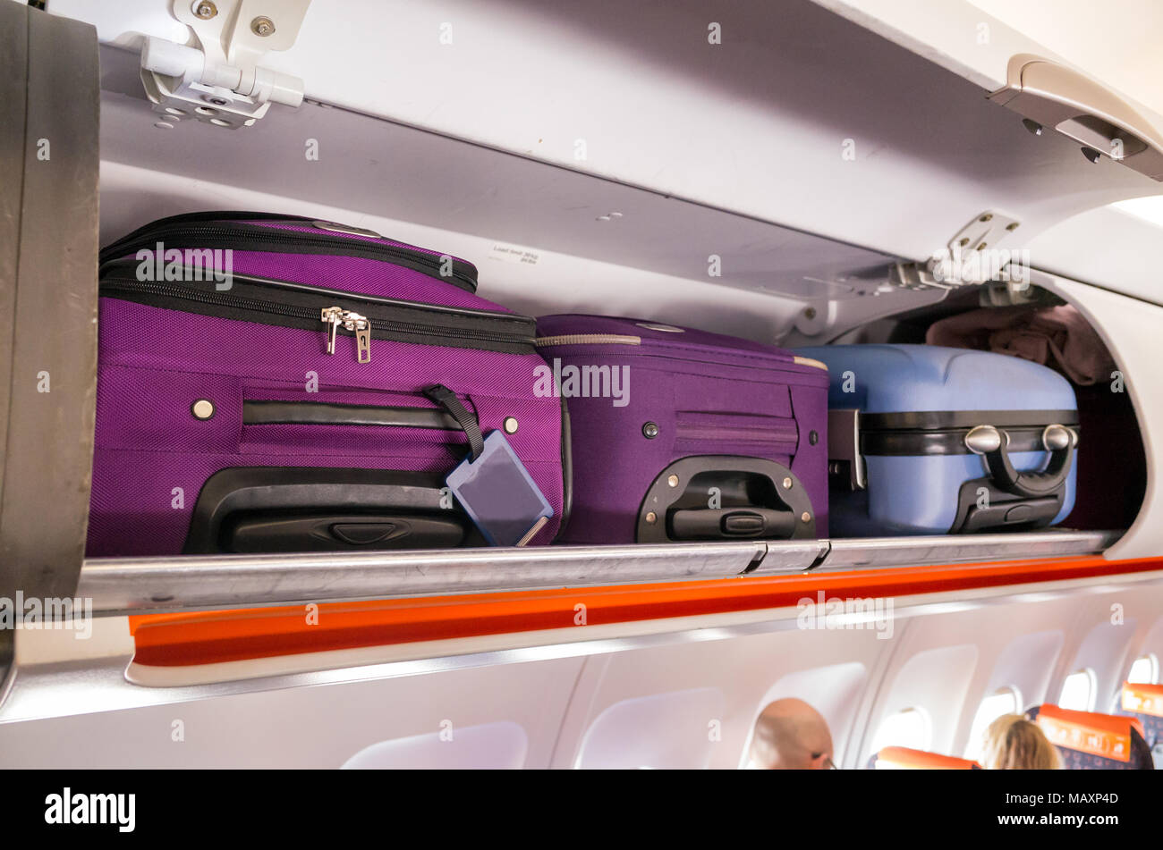 Hand luggage in the cabin overhead lockers of a passenger airplane Stock Photo