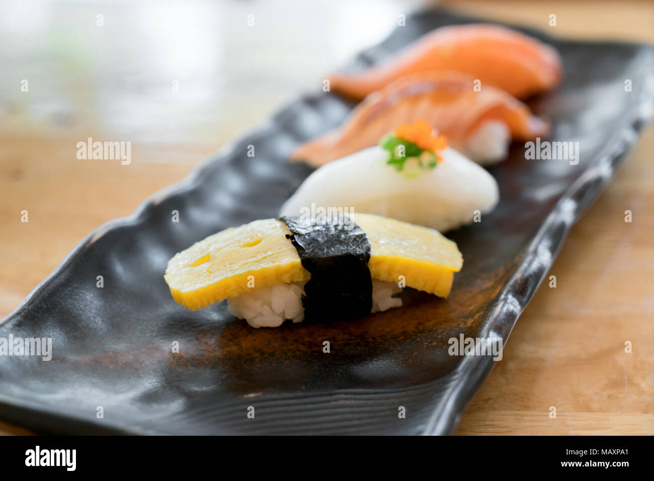 Close up of japanese cuisines nigiri sushi set on black plate served in japanese food restaurant. Stock Photo