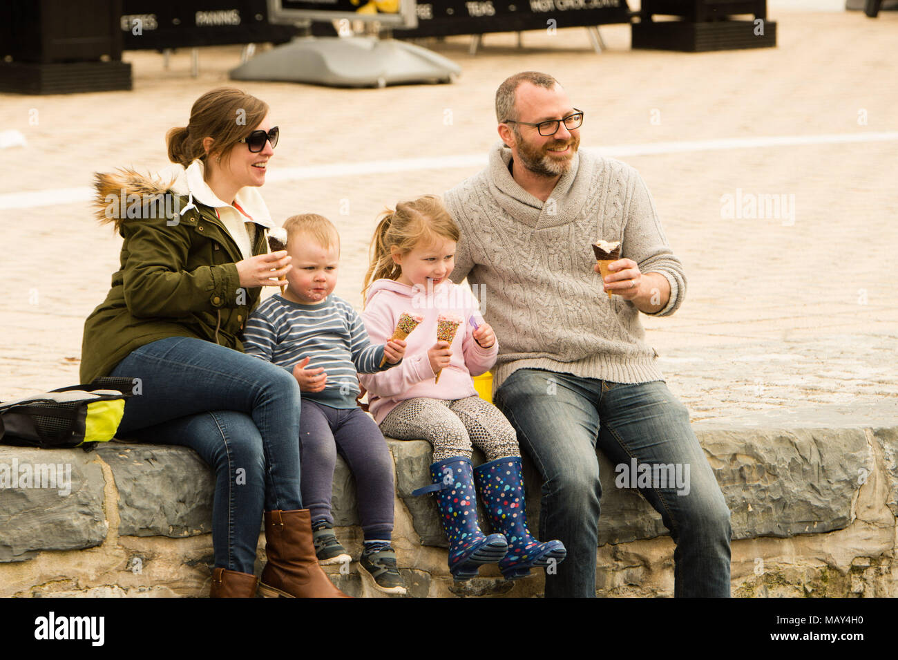 Aberystwyth Wales UK, Thursday  05 April 2018  UK Weather: A family eating icecreams   enjoying an afternoon of warm spring sunshine, with temperatures in the low teens Centigrade,  at the seaside in Aberystwyth on the west coast of Wales   photo © Keith Morris / Alamy Live News Stock Photo