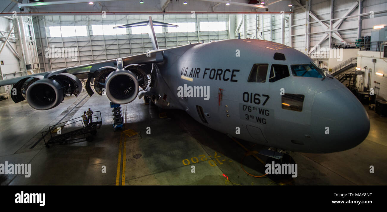 A C-17 Globemaster III assigned to the 176th Wing sits inside a hangar for a home station check at Joint Base Elmendorf-Richardson, Alaska, March 27, 2018. The 3rd and 176th maintenance squadrons complete an in-depth, four-day scheduled inspection of a C-17 approximately every 180 days. A home station check is the behind-the-scenes maintenance that can prevent loss of life, lead to savings in time and money and keep the aircraft fit to fight. (U.S. Air Force photo by Senior Airman Curt Beach) Stock Photo