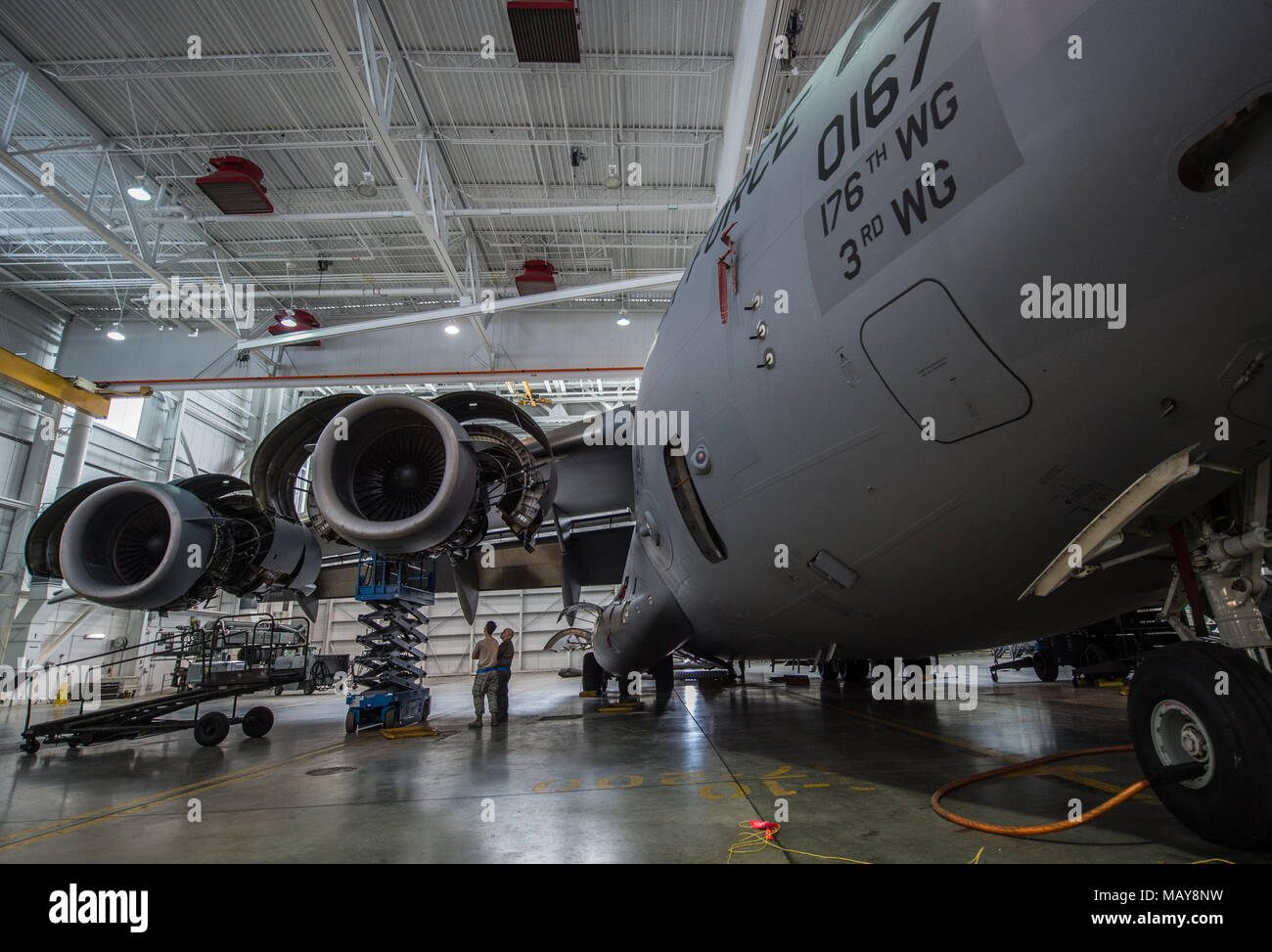 A C-17 Globemaster III assigned to the 176th Wing sits inside a hangar for a home station check at Joint Base Elmendorf-Richardson, Alaska, March 27, 2018. The 3rd and 176th maintenance squadrons complete an in-depth, four-day scheduled inspection of a C-17 approximately every 180 days. A home station check is the behind-the-scenes maintenance that can prevent loss of life, lead to savings in time and money and keep the aircraft fit to fight. (U.S. Air Force photo by Senior Airman Curt Beach) Stock Photo