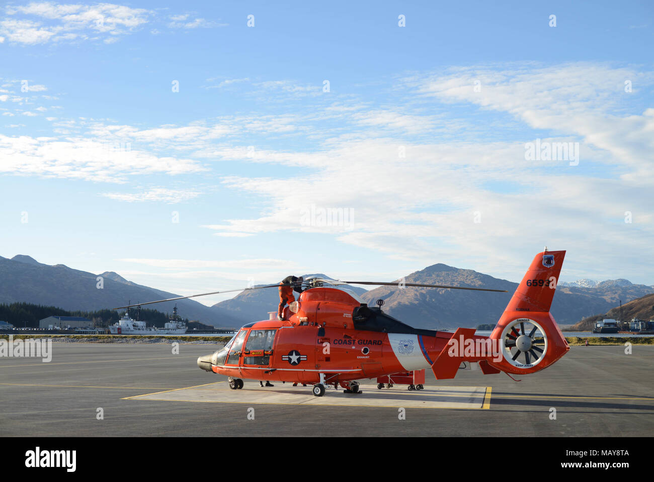 A Coast Guard Air Station Kodiak MH-65 Dolphin helicopter crew conducts a preflight on a Dolphin helicopter at Air Station Kodiak, Alaska, Nov. 3, 2017. Dolphin helicopters deploy aboard cutters to conduct Coast Guard missions in the Alaska patrol division. U.S. Coast Guard photo by Petty Officer 1st Class Charly Hengen. Stock Photo