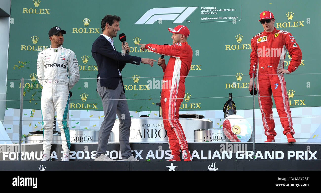Race Winner Sebastian Vettel of Scuderia Ferrari talking to Mark Webber, while 2nd place Lewis Hamilton of Mercedes AMG Petronas Motorsport and 3rd place Kimi Raikkonen of Scuderia Ferrari look on.  Day 4, Race Day, of the 2018 Formula 1 Rolex Australian Grand Prix held at The circuit of Albert Park, Melbourne, Victoria on the 25th March 2018. Wayne Neal | SportPix.org.uk Stock Photo