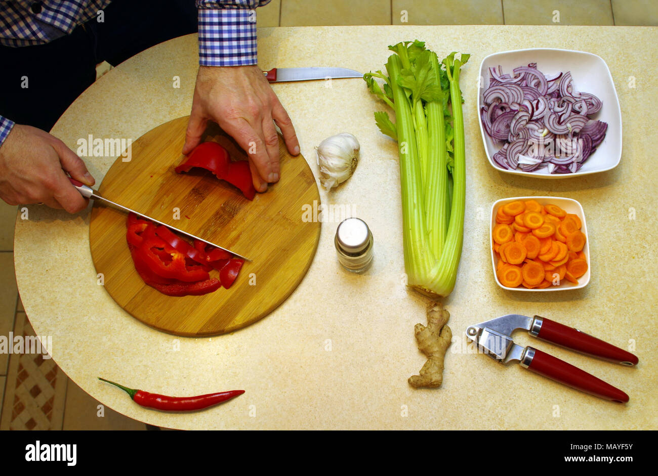 Vegetarian food cutting and preparing by man. View from top for board with vegetable nutrition. Stock Photo