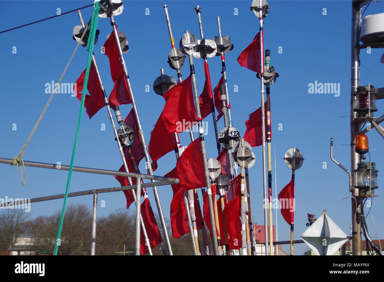 A jagged red flags in the wind on fishing boat Stock Photo