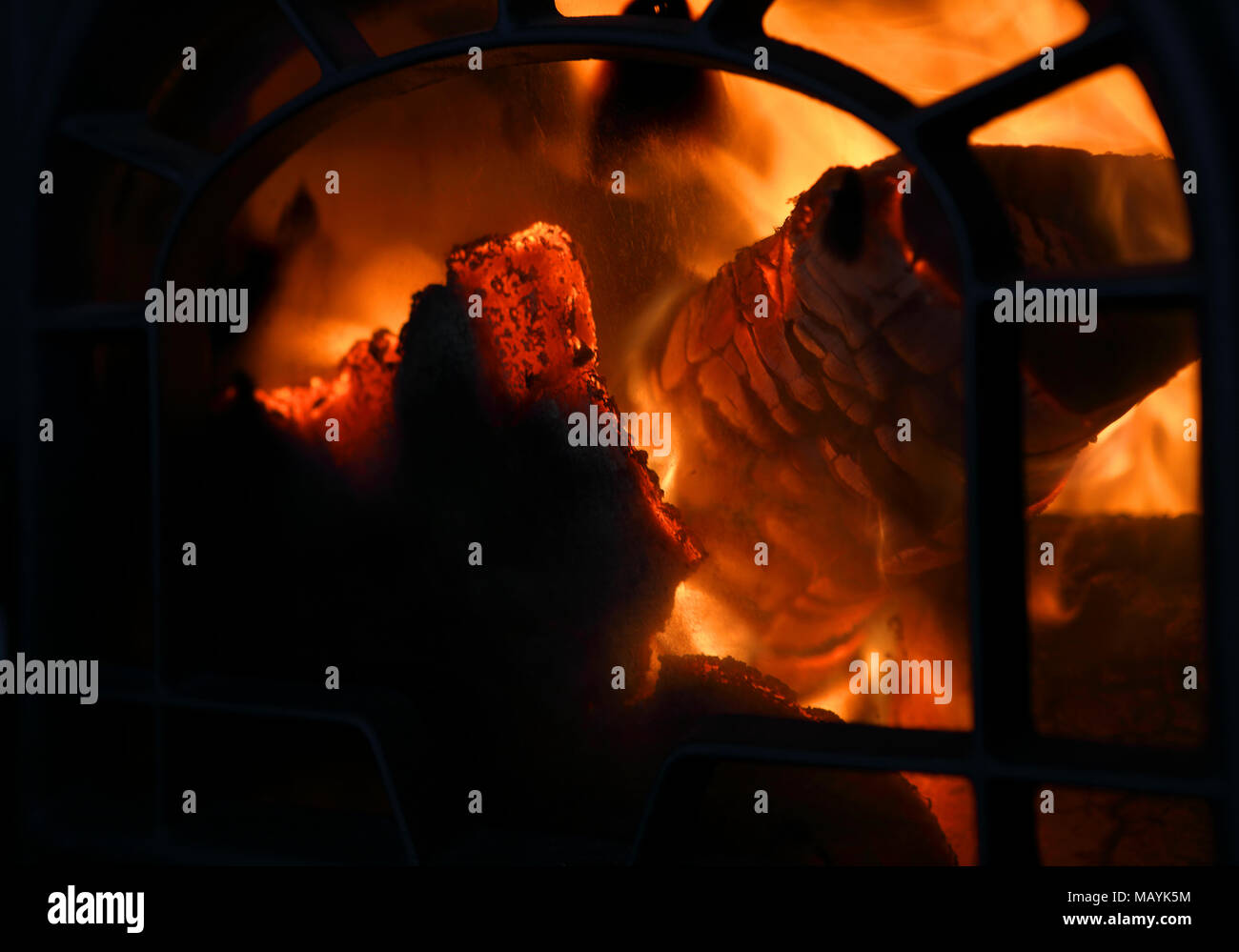 Firewood burning in old iron oven. Close up with copy space for text