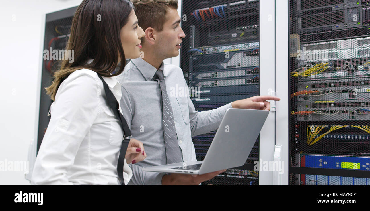Technicians using laptop while analyzing server in server room Stock Photo