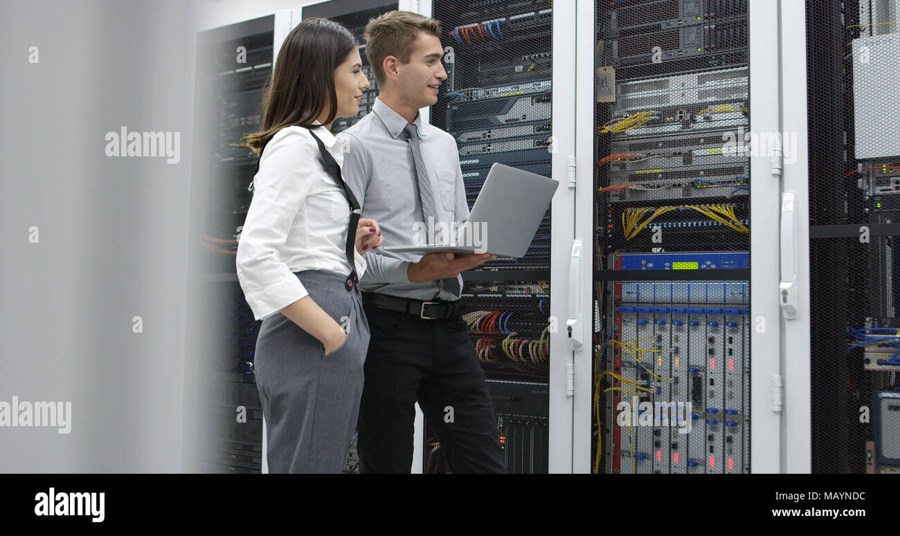 Technicians using laptop while analyzing server in server room Stock Photo