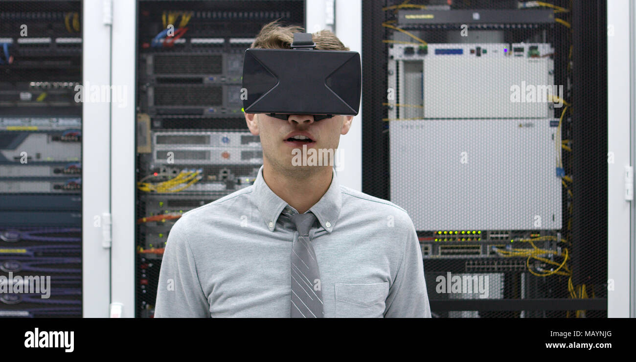 young IT engeneer using virtual reality headset over server room background Stock Photo