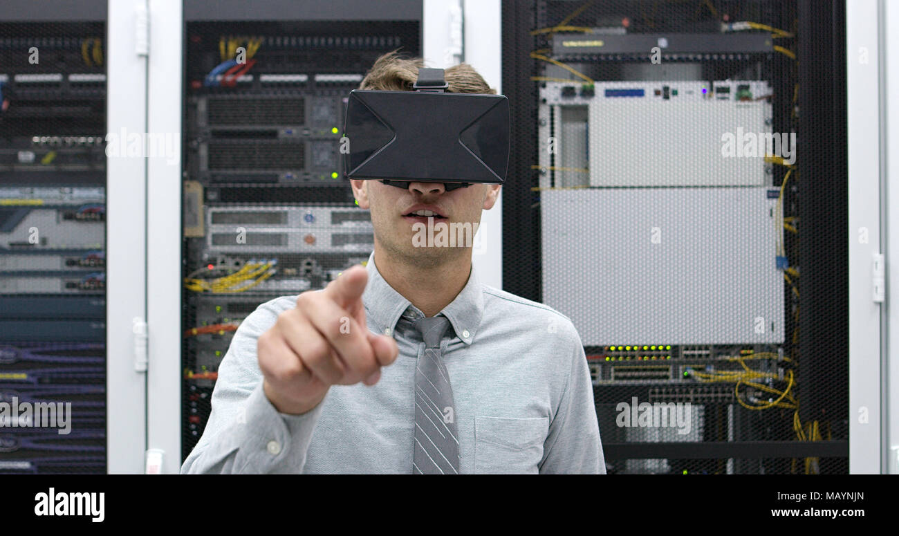 young IT engeneer using virtual reality headset over server room background Stock Photo