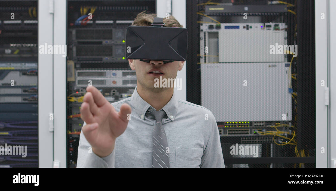 young IT engeneer using virtual reality headset over server room background Stock Photo