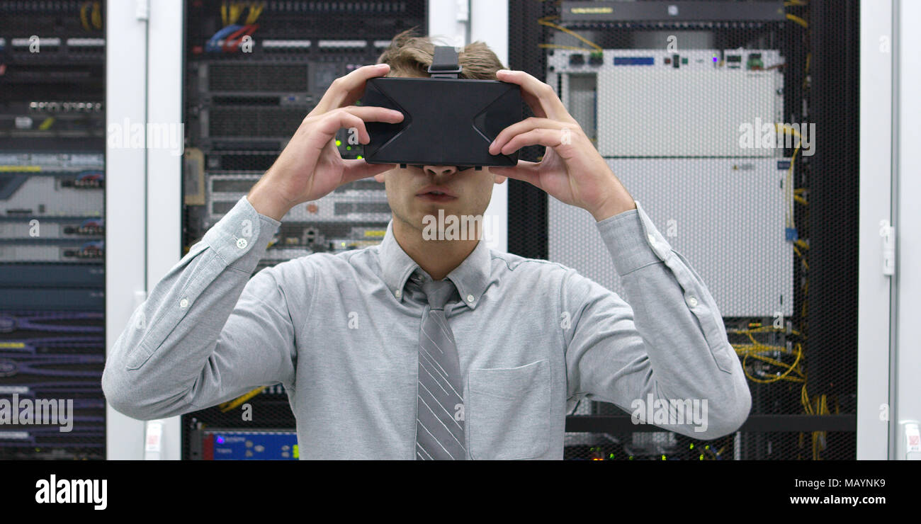 young IT engeneer using virtual reality headset over server room background Stock Photo