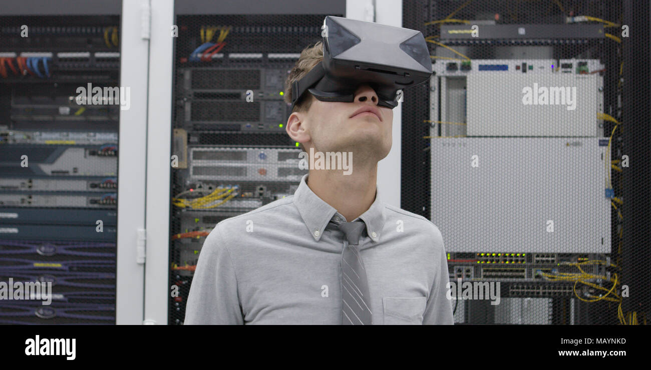 young IT engeneer using virtual reality headset over server room background Stock Photo