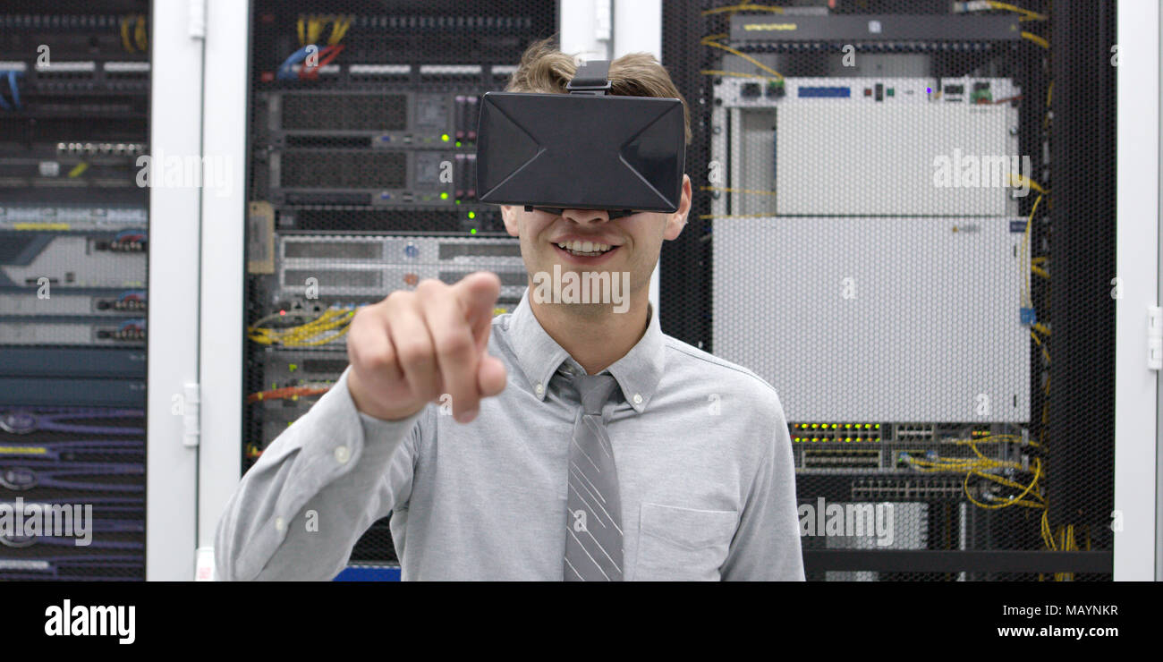 young IT engeneer using virtual reality headset over server room background Stock Photo