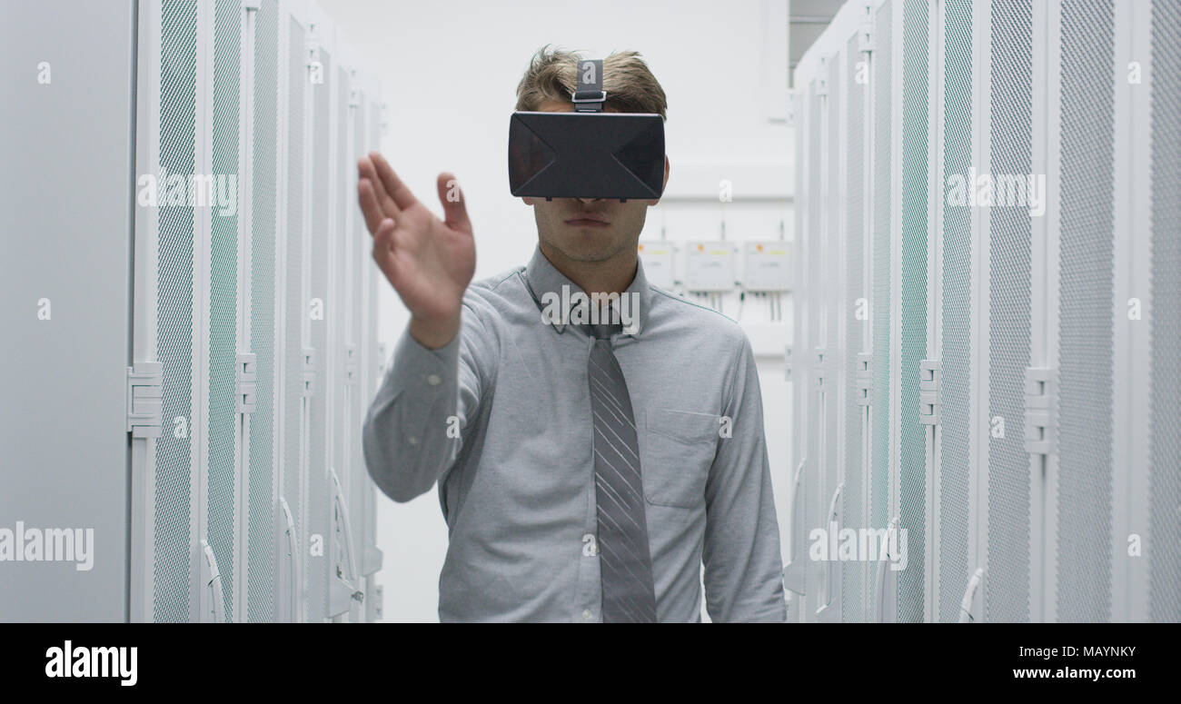 young IT engeneer using virtual reality headset over server room background Stock Photo