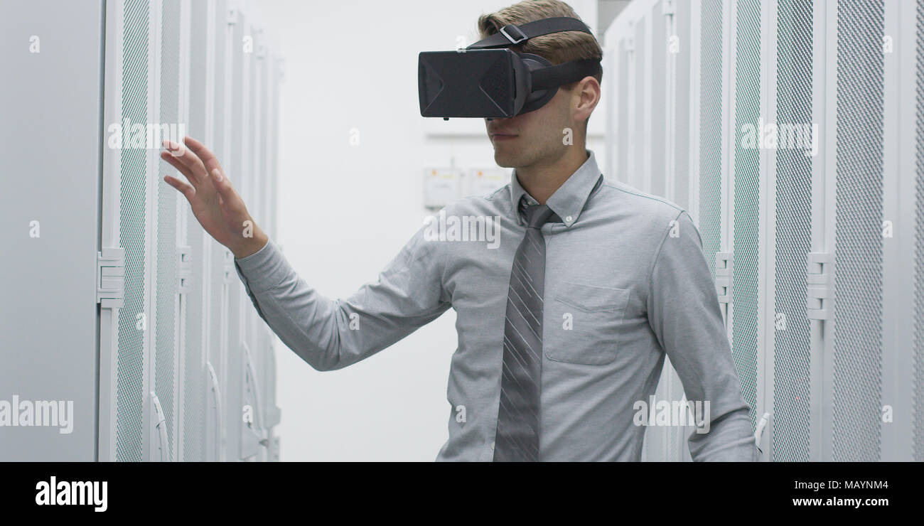 young IT engeneer using virtual reality headset over server room background Stock Photo
