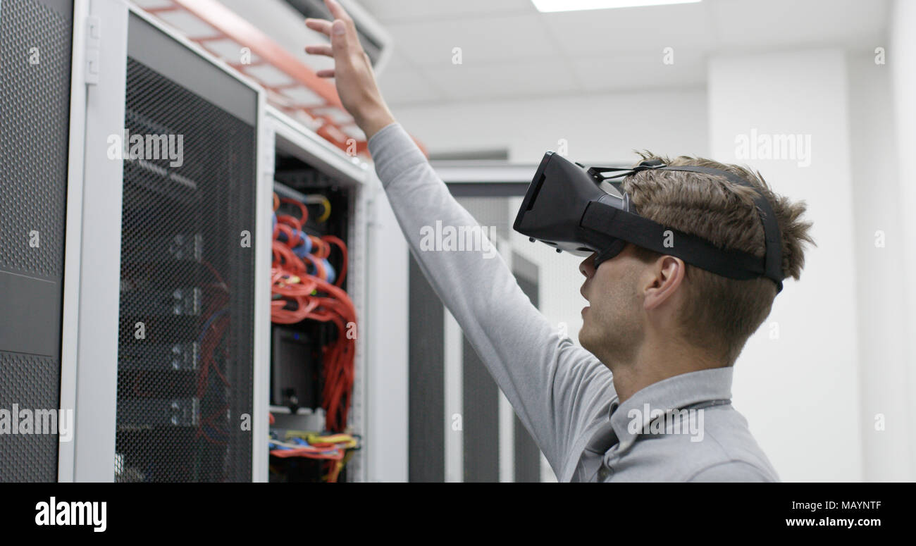 young IT engeneer using virtual reality headset over server room background Stock Photo