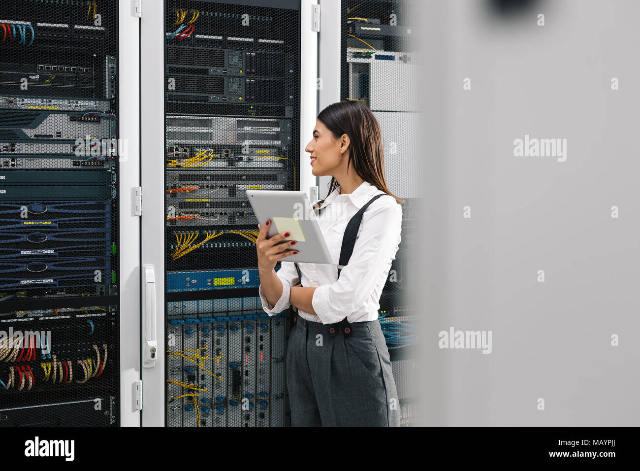 Technicians using laptop while analyzing server in server room Stock Photo