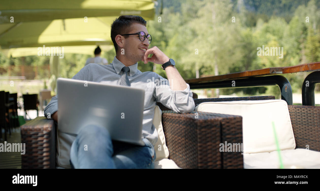 Young businessman casually dressed working outside in caffe bar. Stock Photo