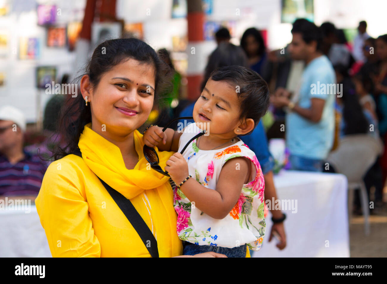 Young woman with her daughter smiling at camera, Empress garden at Pune Stock Photo