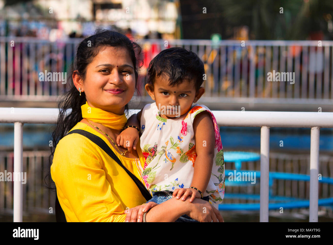 Young woman with her daughter smiling at camera, Empress garden at Pune Stock Photo