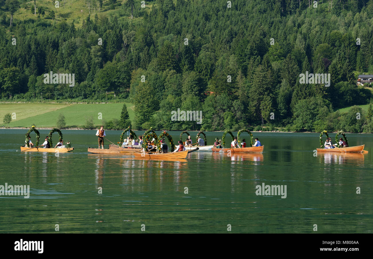 Men wearing traditional costumes in festively decorated squares, wooden boats, on the Schliersee lake, Alt-Schlierseer-Kirchtag Stock Photo